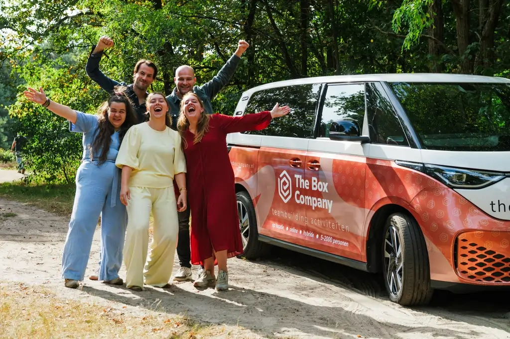 het team van The Box Company staand naast een van hun bussen