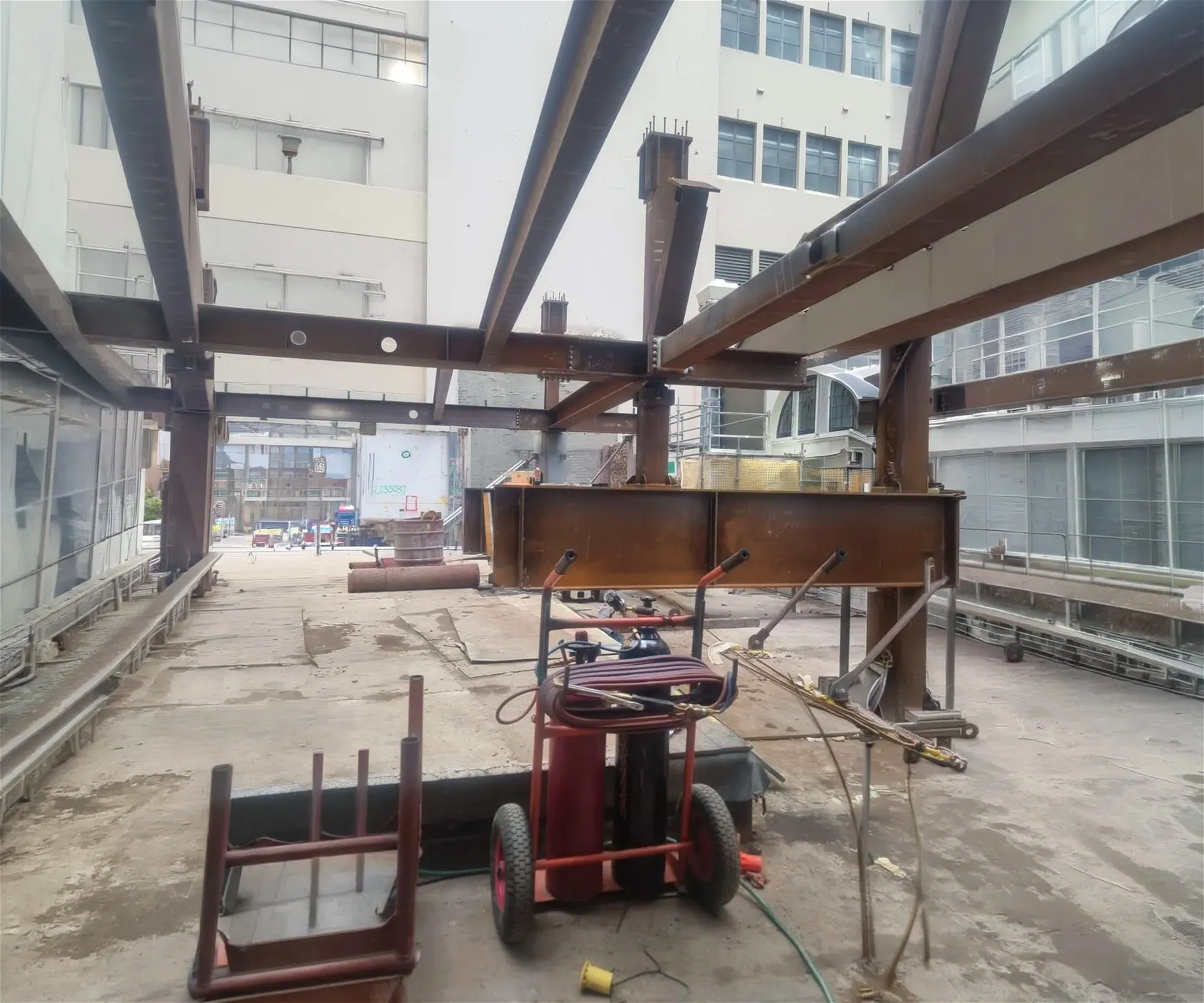 Construction site with steel beams and cart