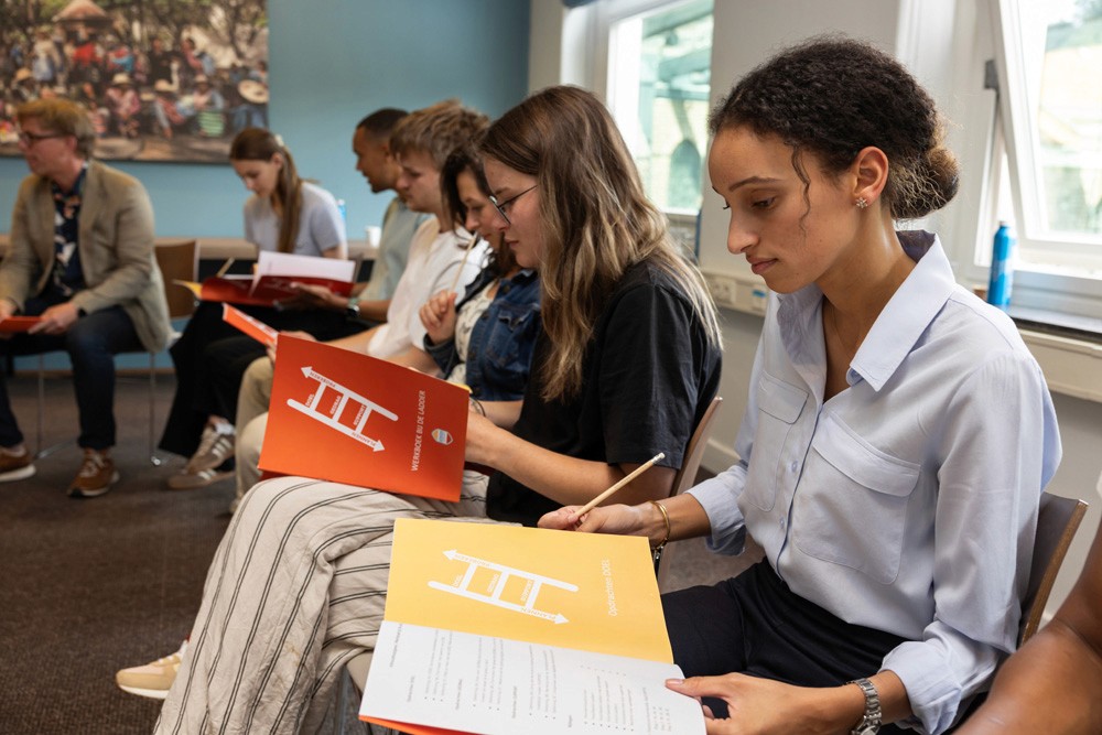 Deelnemers met het boekje De Ladder
