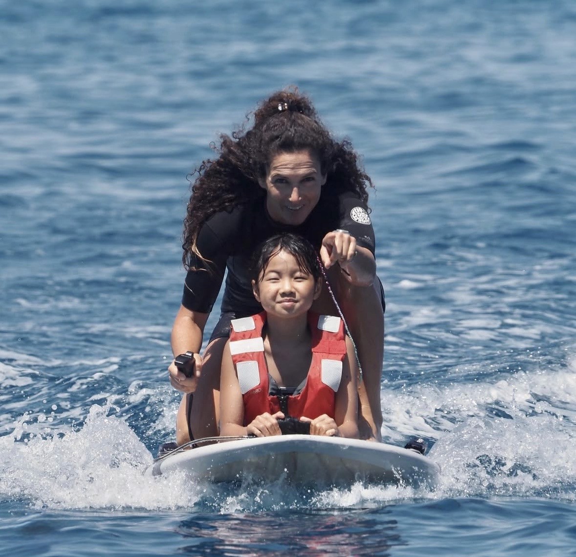 Deux personnes découvrant le eFoil Revo ARIA sur l'eau à l'île Maurice, encadrées par EFOIL Mauritius