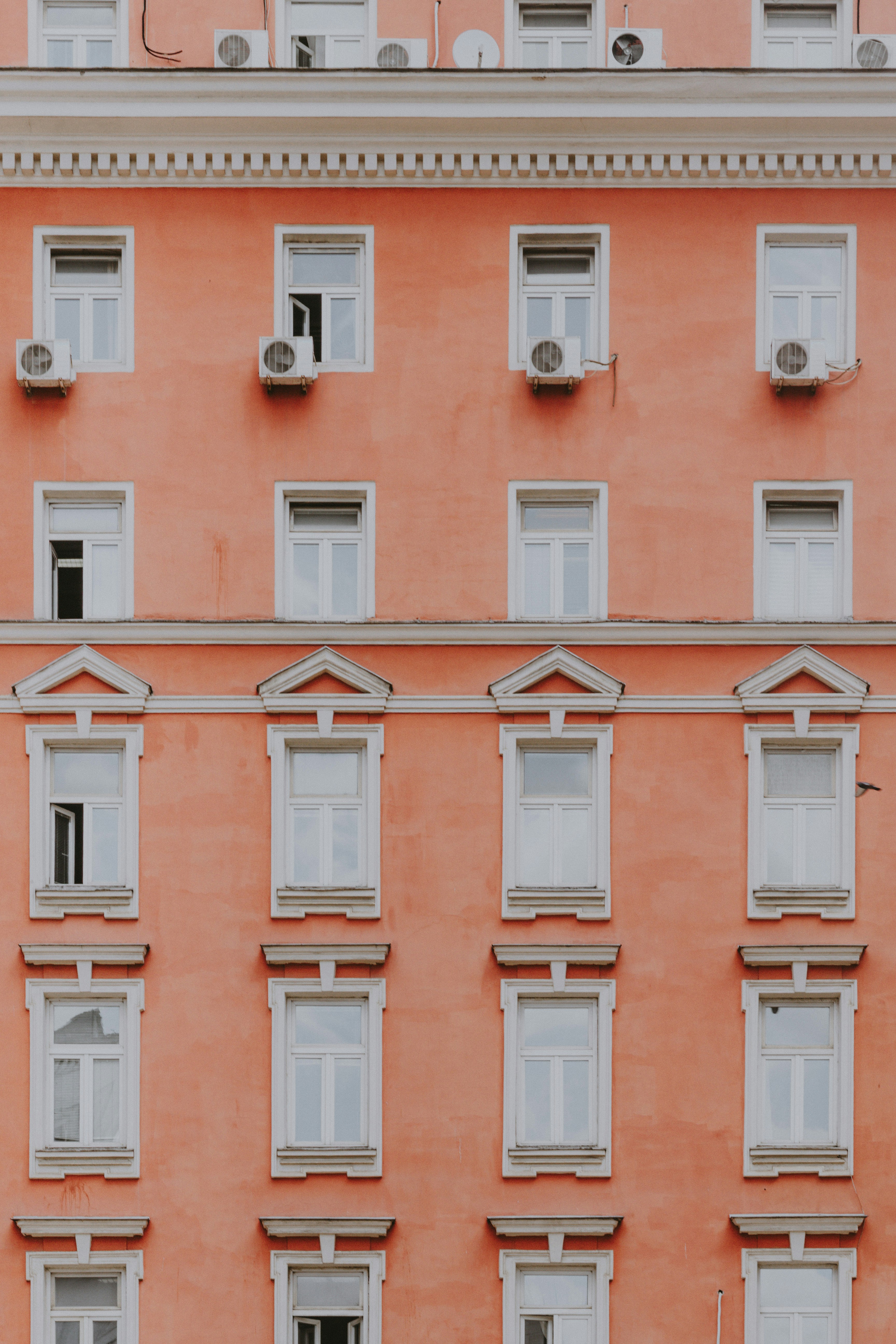 Rows of white windows on a salmon-colored building.