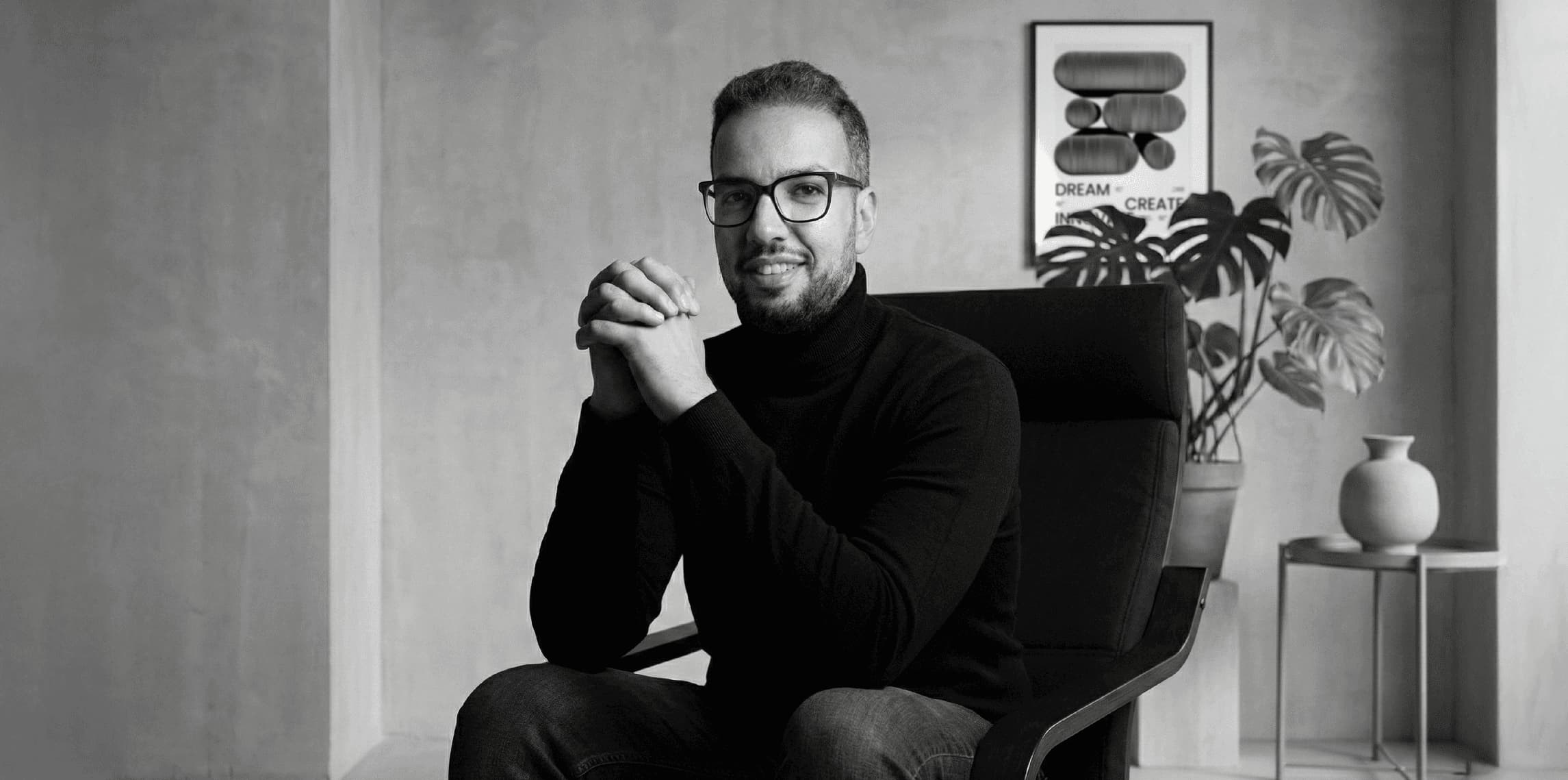 Person seated in a modern office with abstract design poster, Beroz Studio theme, showcasing interface design elements.