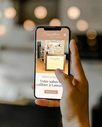 Site internet Signature Coiffure affiché sur téléphone tenu en main