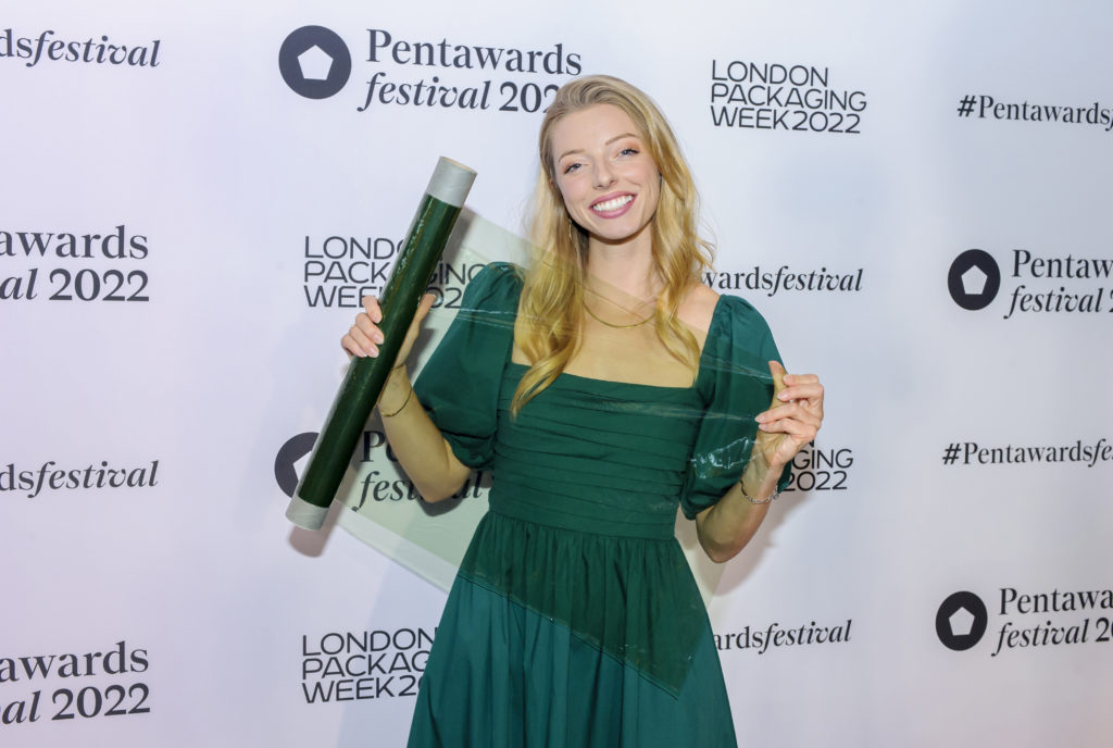 woman holding seaweed product sample in a green dress