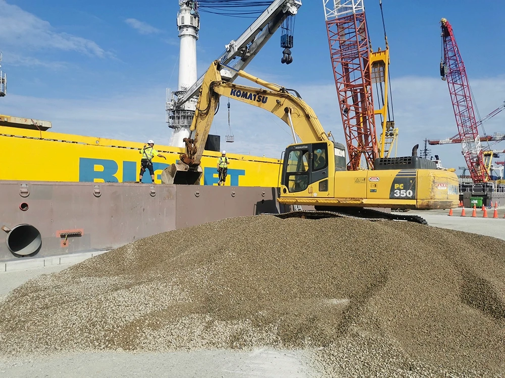 Heavy machinery operating on an industrial site with construction materials.