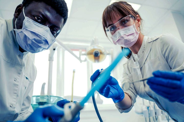 Patient Mouth view camera of two dentists operating a surgery.