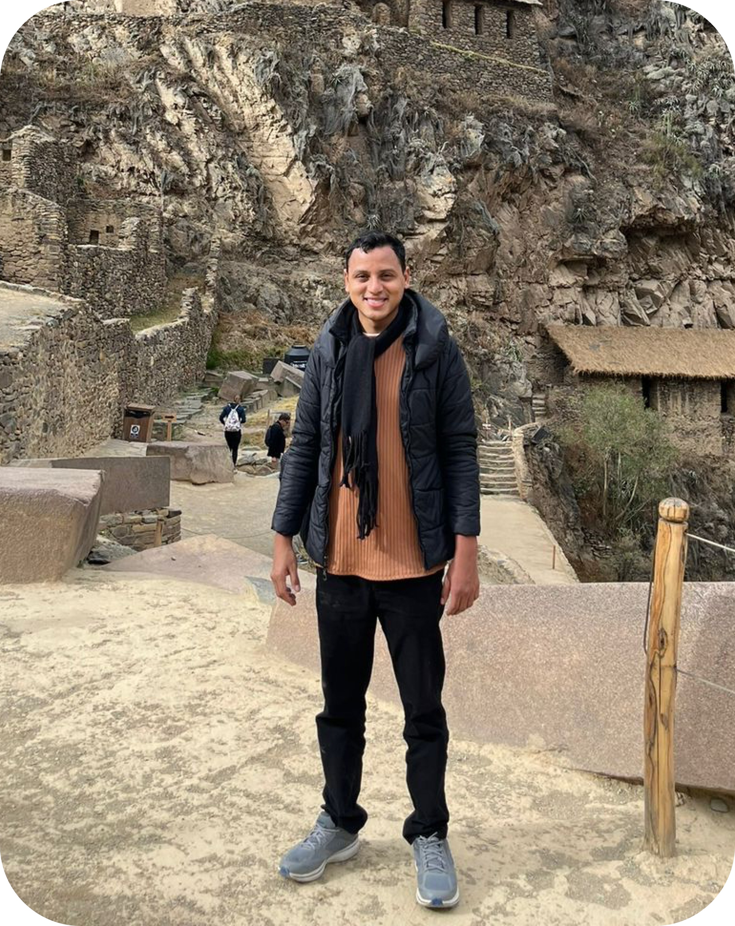 Man sitting in a dimly lit room, wearing a beige shirt and looking contemplative.