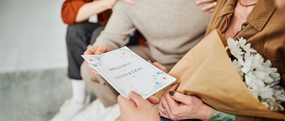 Guests holding a wedding invitation