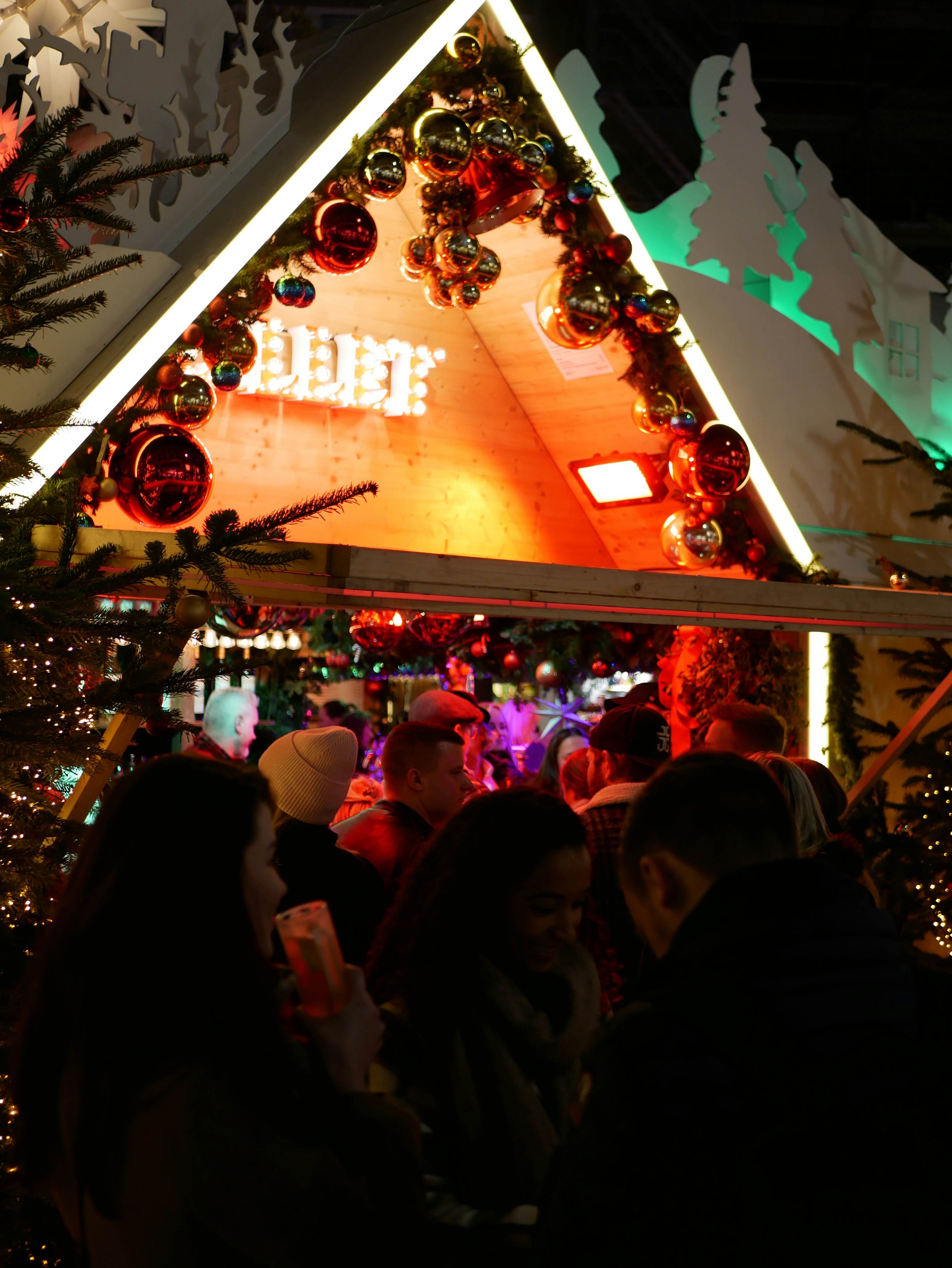 a group of people standing in front of a christmas display