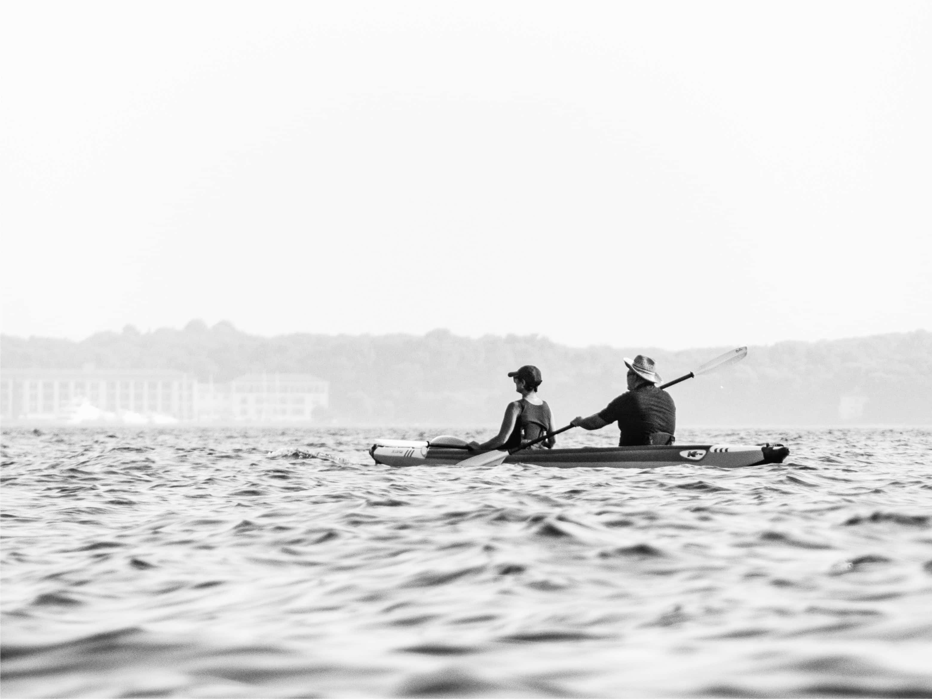 Middle-aged couple kayaking in a large body of water in a warm weather