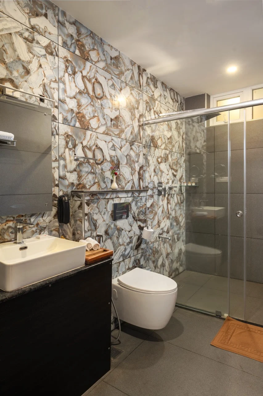 Classic Room Bathroom at Au Revoir Wellness Resort – Elegant Design with Modern Fixtures and a Glass-Enclosed Shower