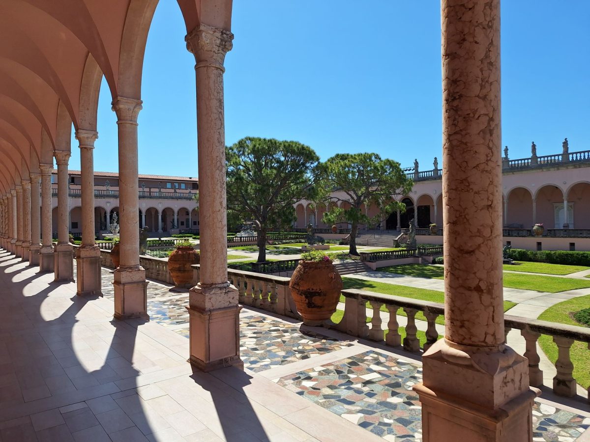 Arched pink stone courtyard colonnade overlooking the manicured garden at The Ringling Museum in Sarasota