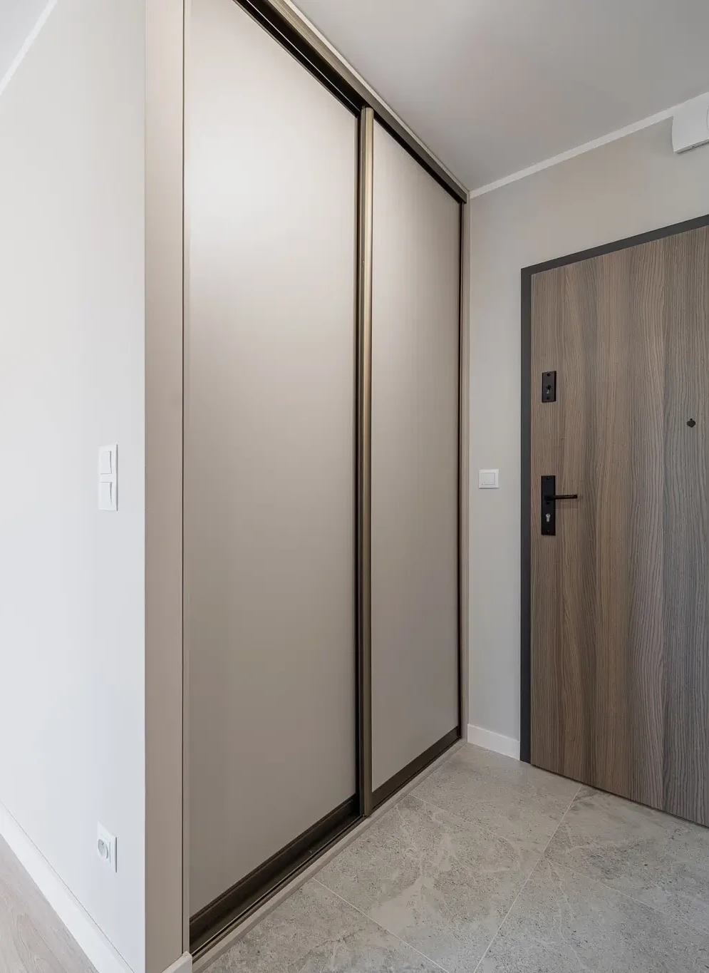 Elegancka szafa przesuwna Kraków w złotych ramach w nowoczesnym przedpokoju na zamówienie.