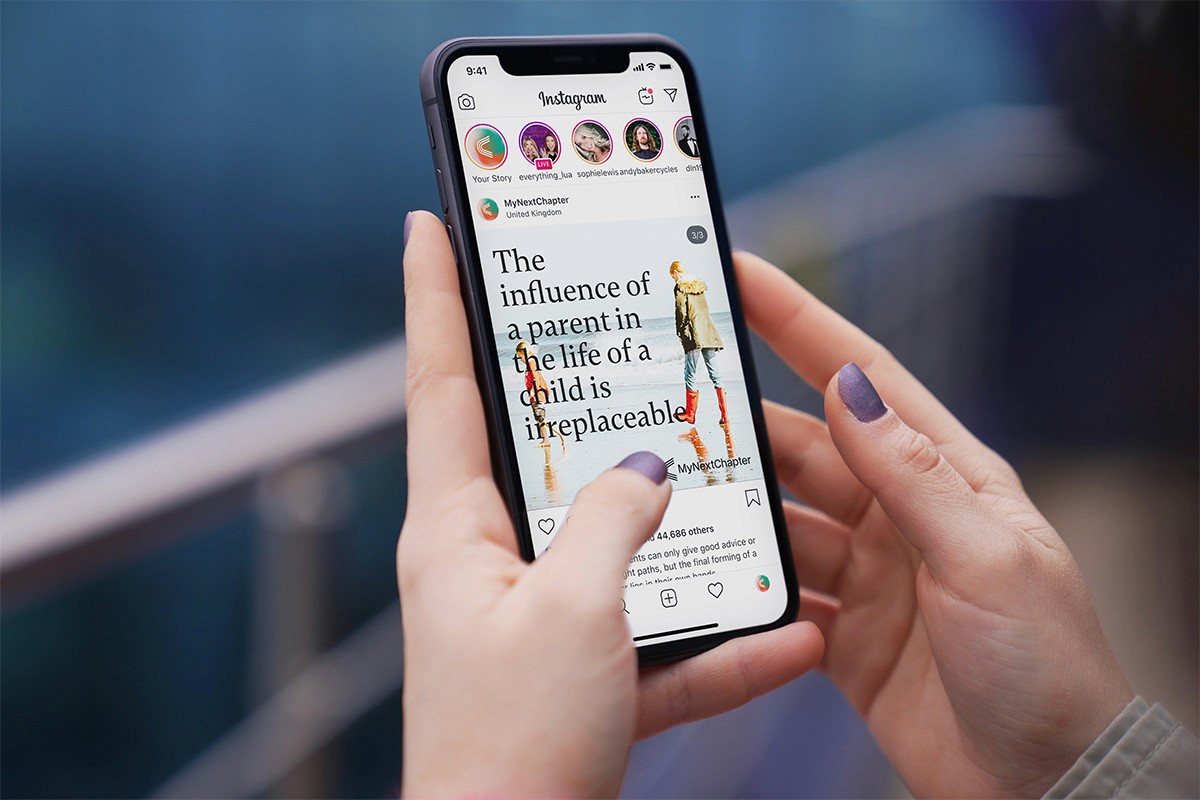 Woman holding phone looking at My Next Chapter post on Instagram