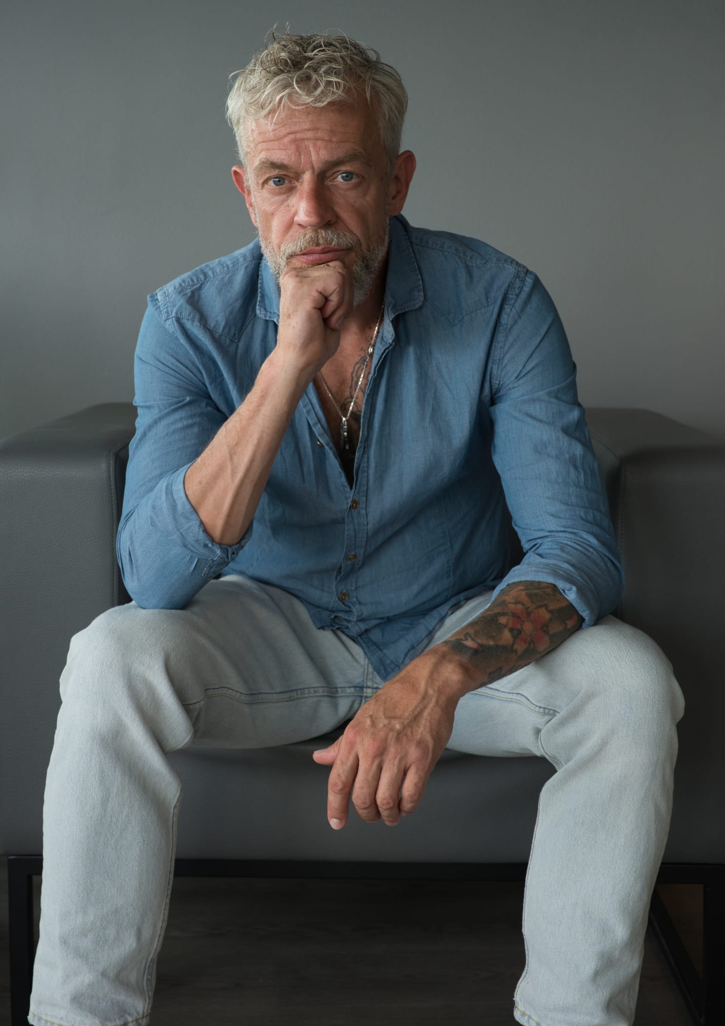 Sitende Mann Best Ager Hand auf knie Präsenter Blick