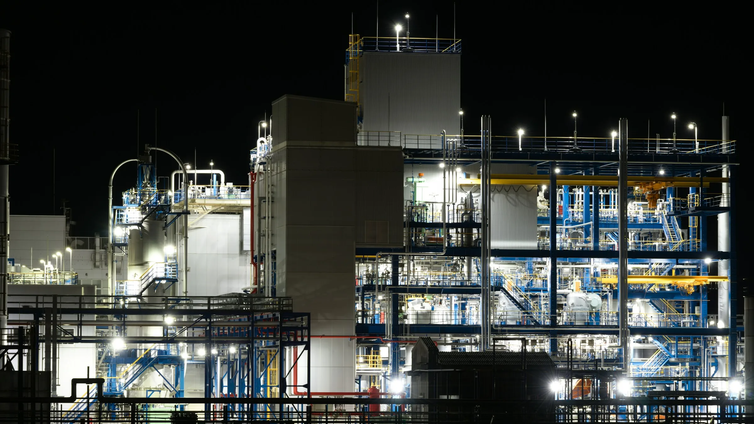 Ammonia and chemical plant lit up at night, with reactor columns, steel structures and process piping