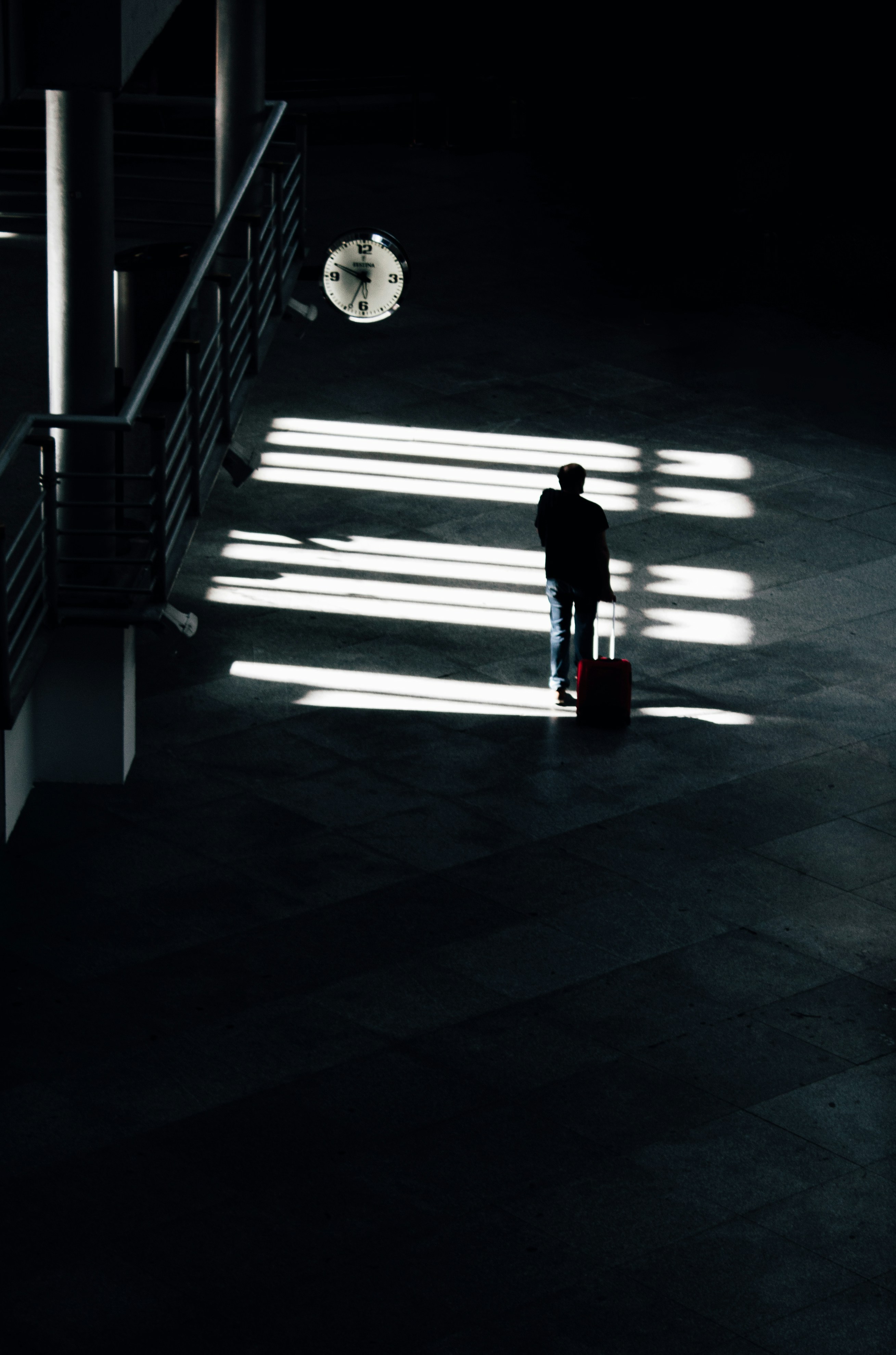 a person standing in a dark room with a suitcase