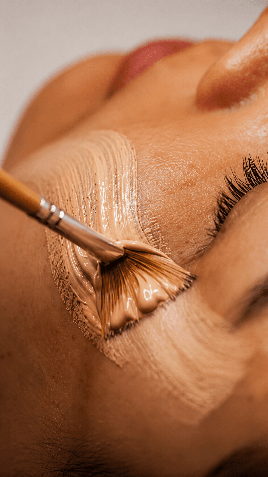 Professional makeup artist applying luxury liquid foundation with a brush during a bridal makeover session.