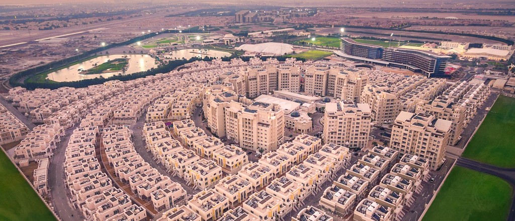 Aerial view of Al Forsan Village, showcasing a sprawling cityscape filled with numerous buildings and urban structures.