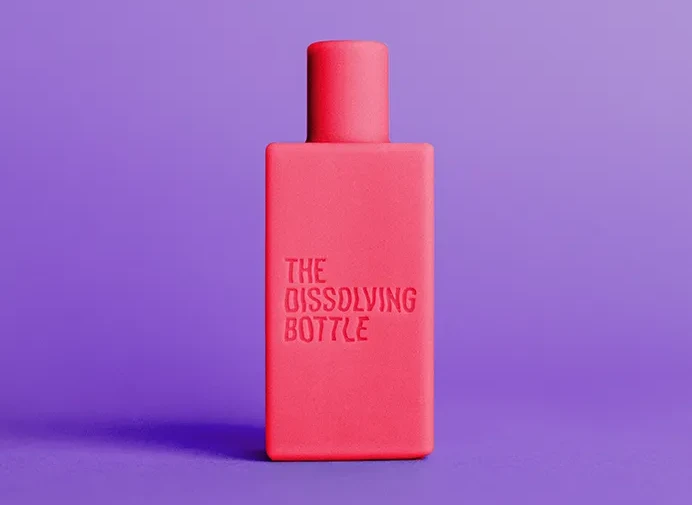 Czerwona butelka z napisem The Dissolving Bottle na fioletowym tle