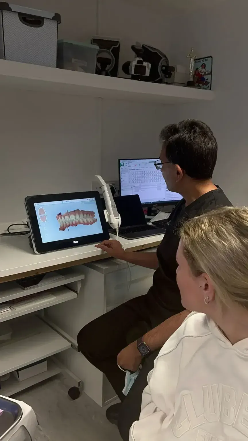 Dr Khalid talking over a scan of the patients teeth to talk about the clear aligners (invisalign) plan.