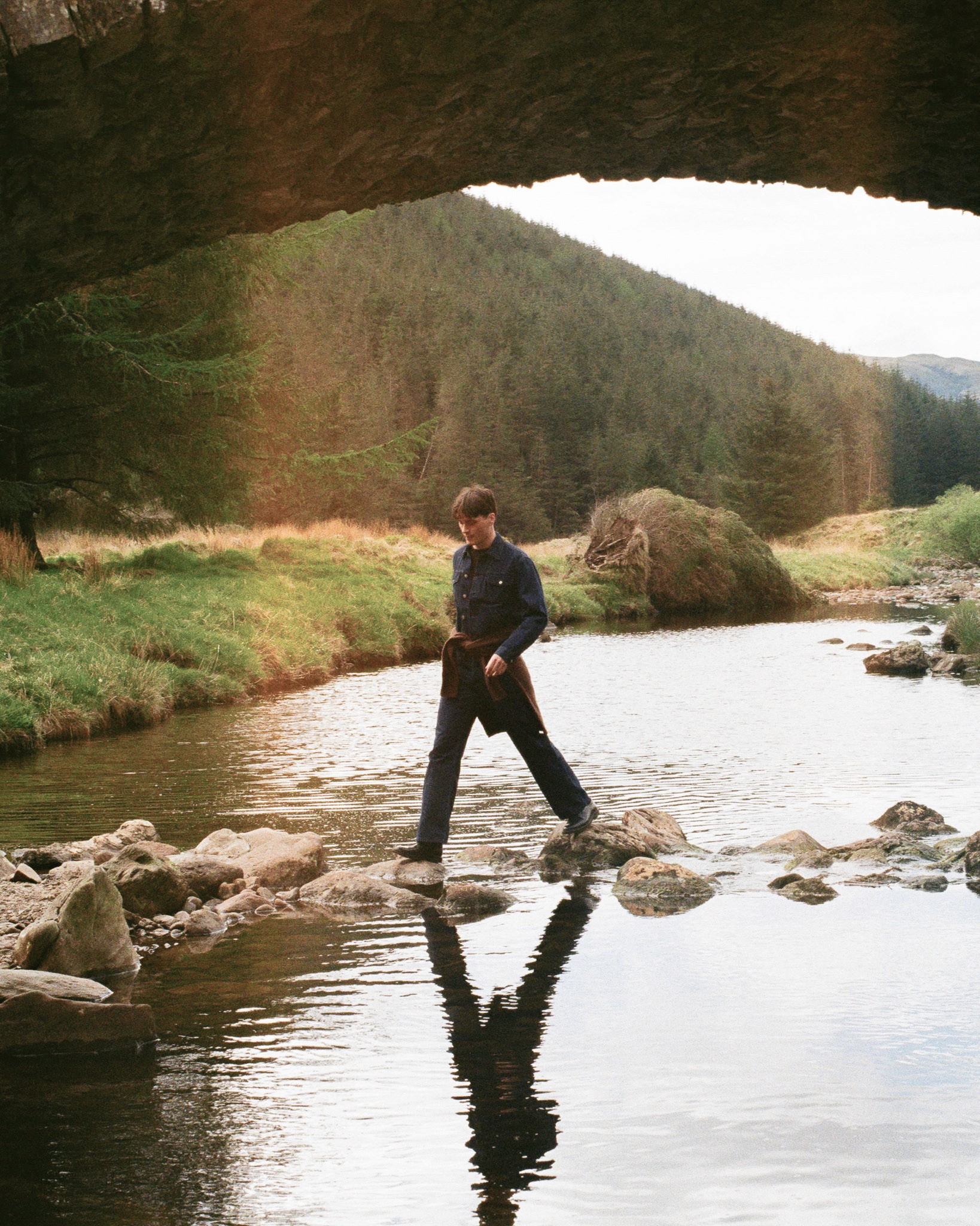 Un mannequin portant un ensemble Another Aspect traverse une rivière dans les highlands Ecossais