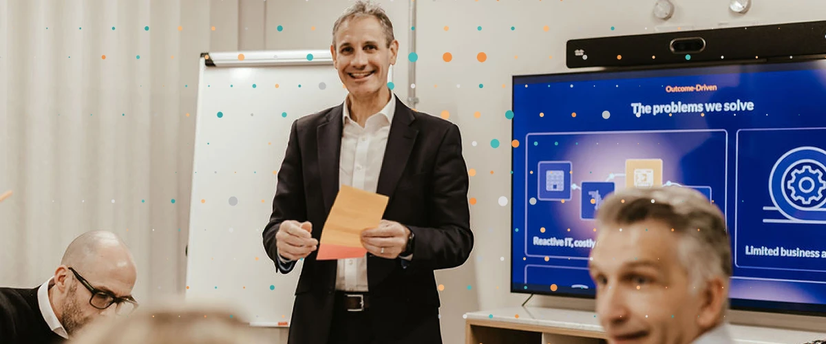 One person standing and presenting to a board room with attendees