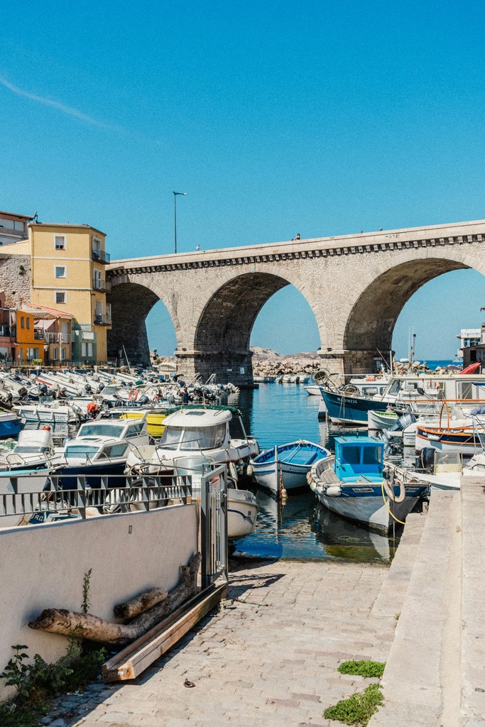 Vue du port du Vallon des Auffes à Marseille avec son pont emblématique en arrière-plan, reflétant l’expertise locale de Croceo en conciergerie Airbnb et gestion de locations saisonnières.