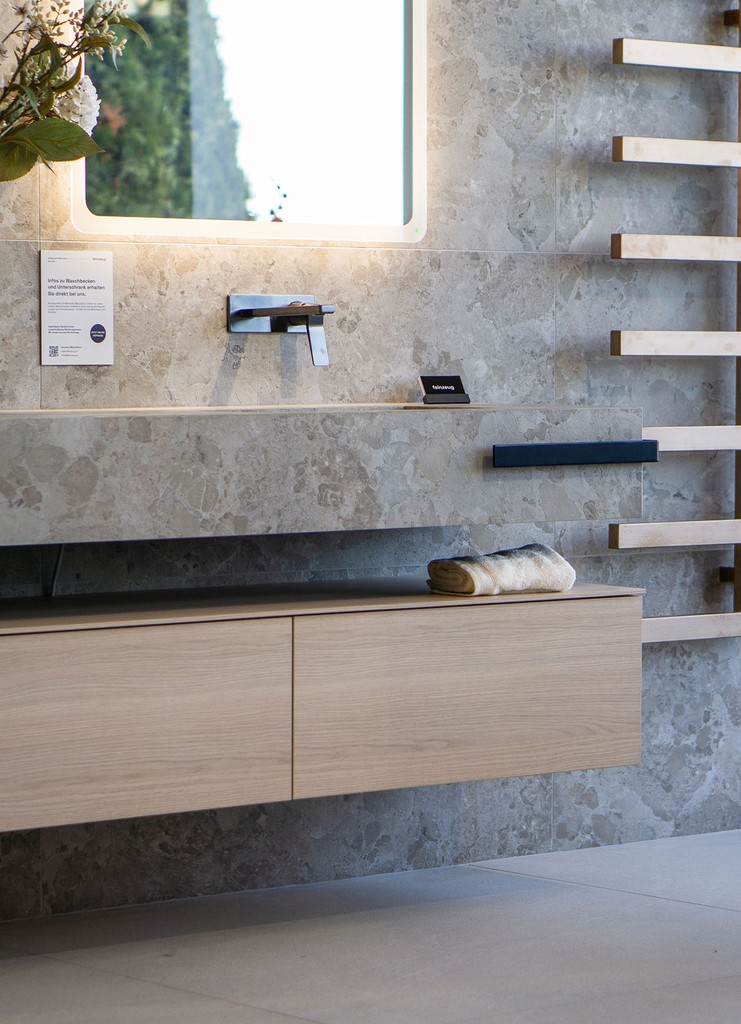 Modern glass and steel building with warm wooden ceilings, surrounded by lush greenery, blending contemporary architecture with nature.