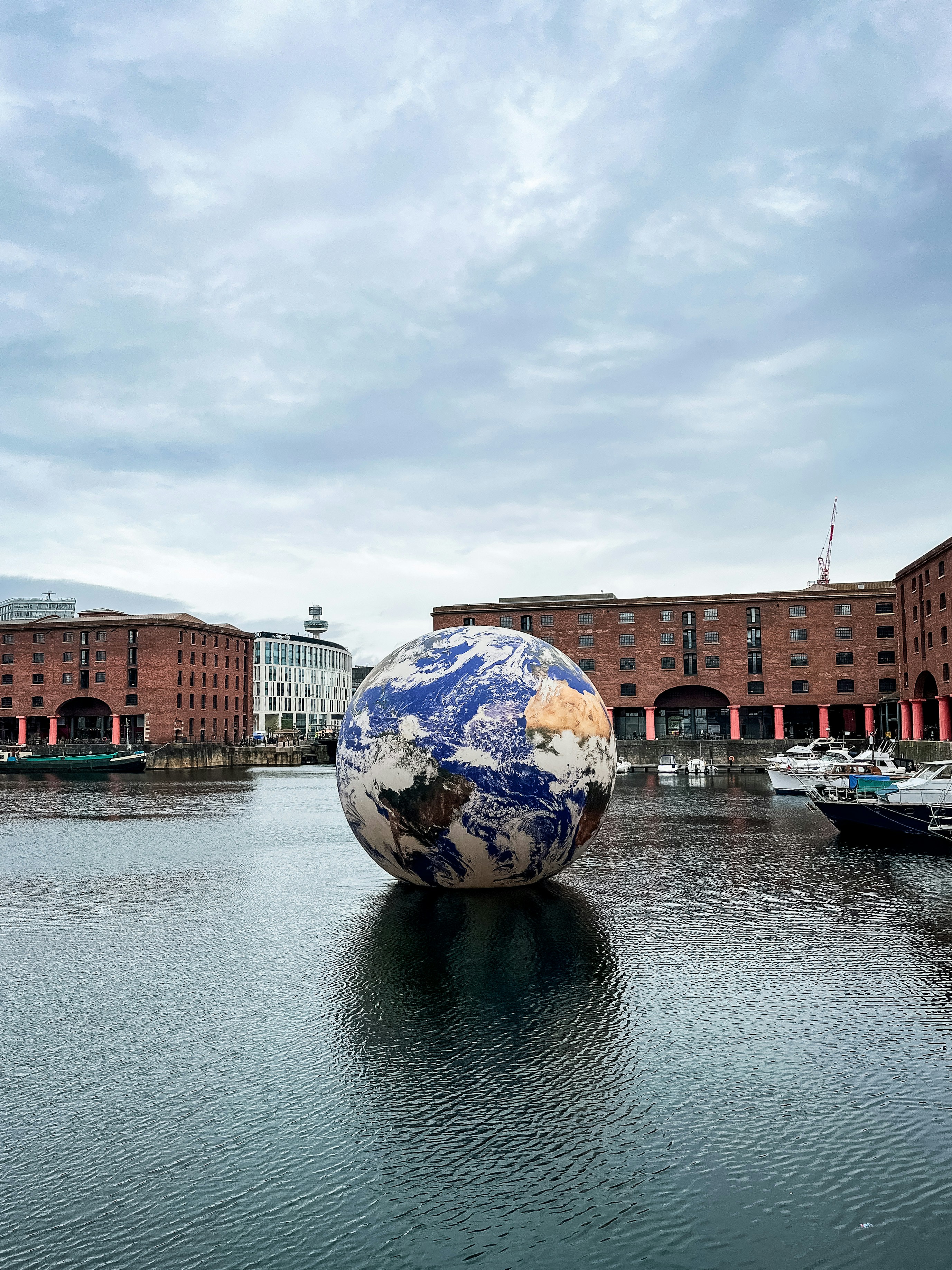 a large blue and white ball sitting on top of a body of water