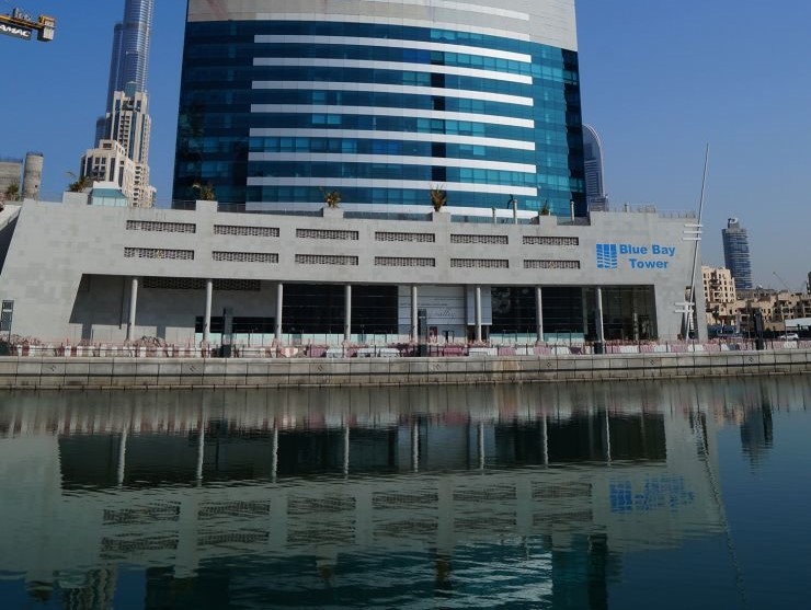 Commercial real estate agent showcasing a waterfront view of Blue Bay Tower in Business Bay.