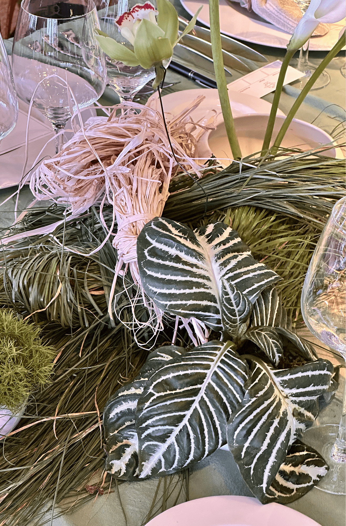 Composición floral conceptual con anturios escultóricos de color rojo intenso y flores blancas silvestres.