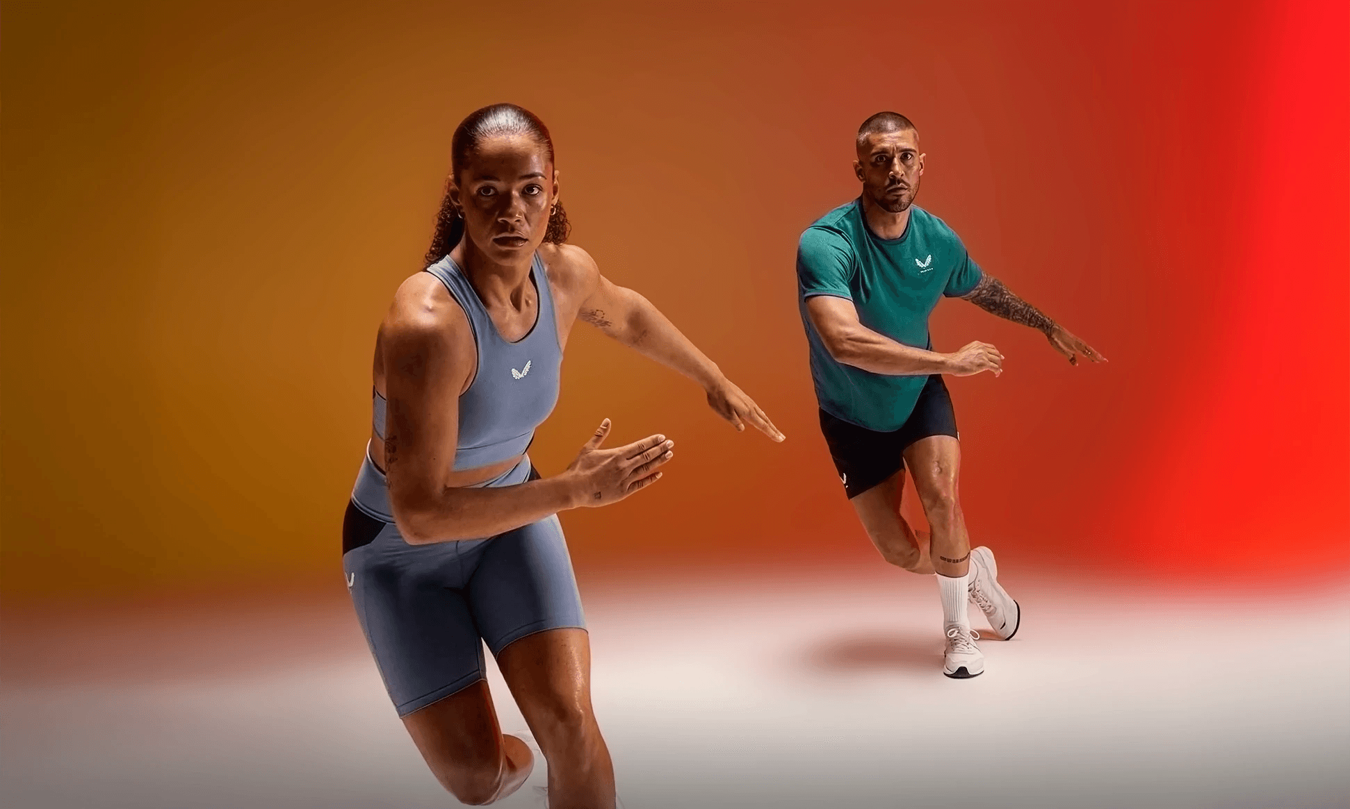 Woman and man in athletic gear performing dynamic exercise.