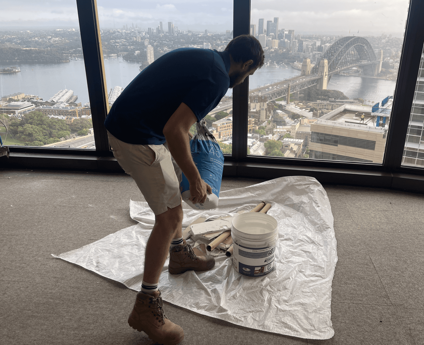Man with bag of supplies by Sydney Harbour Bridge view