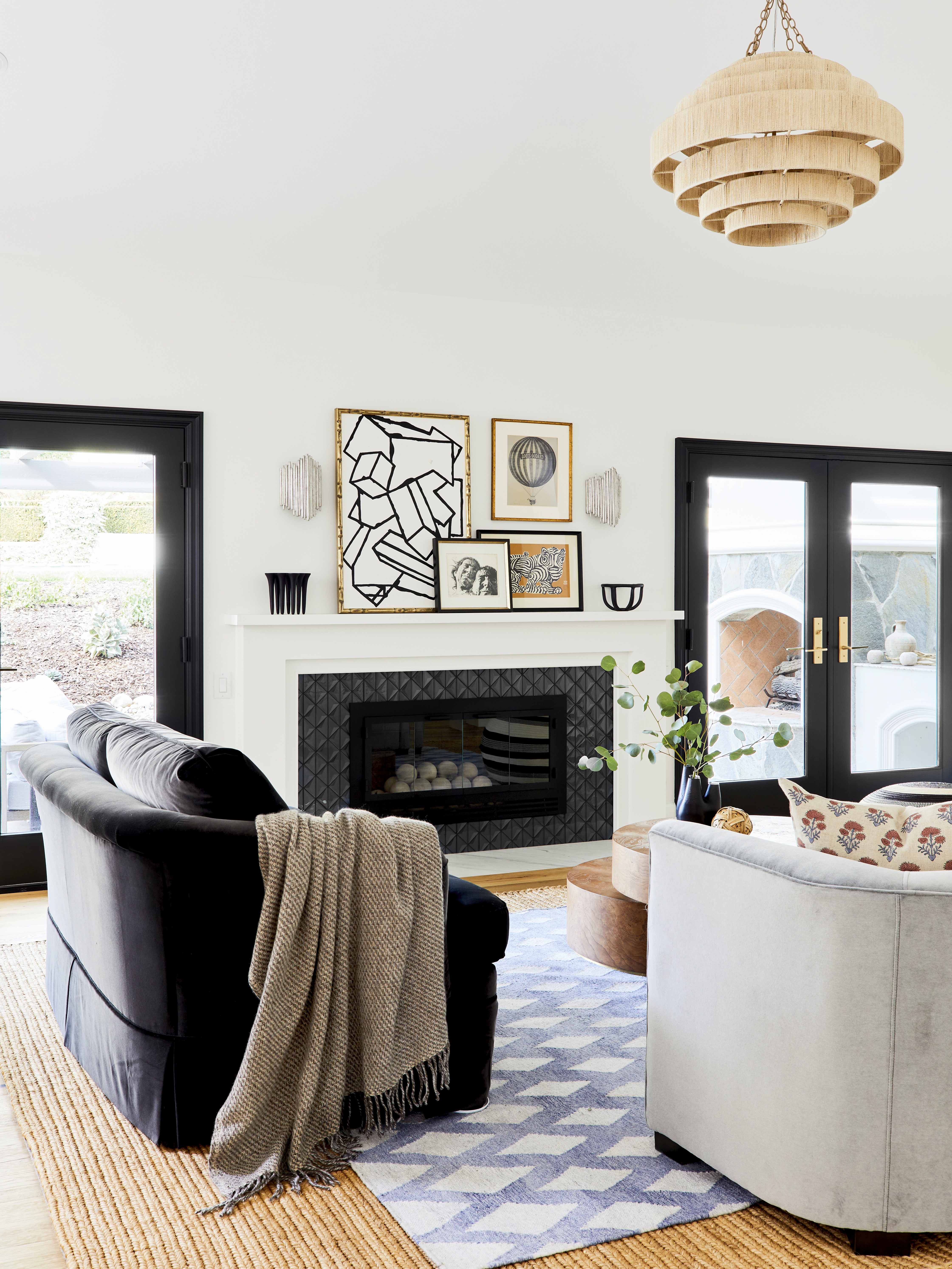 This inviting outdoor retreat features a stone fire-pit, plush sectional seating, and hanging wicker lights, blending earthy tones and natural materials for a cozy, stylish space