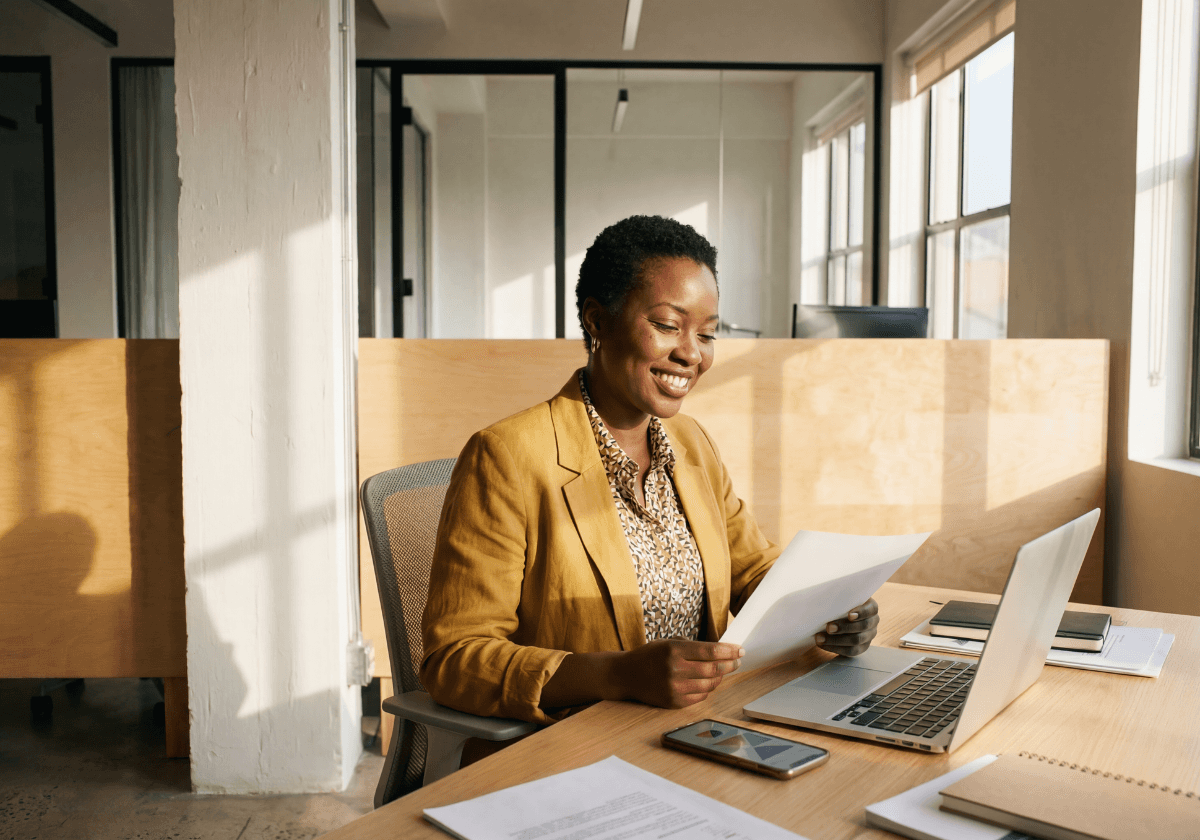 Aerial view of a winding road surrounded by dense green and yellow trees, showcasing nature’s vibrant colors.