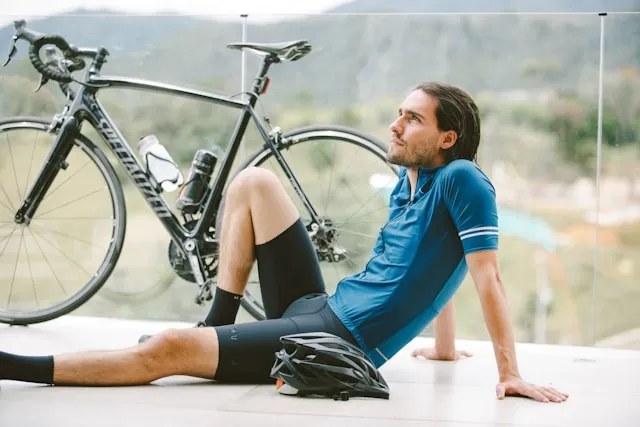 Road bike resting beside a seated cyclist outdoors during a break