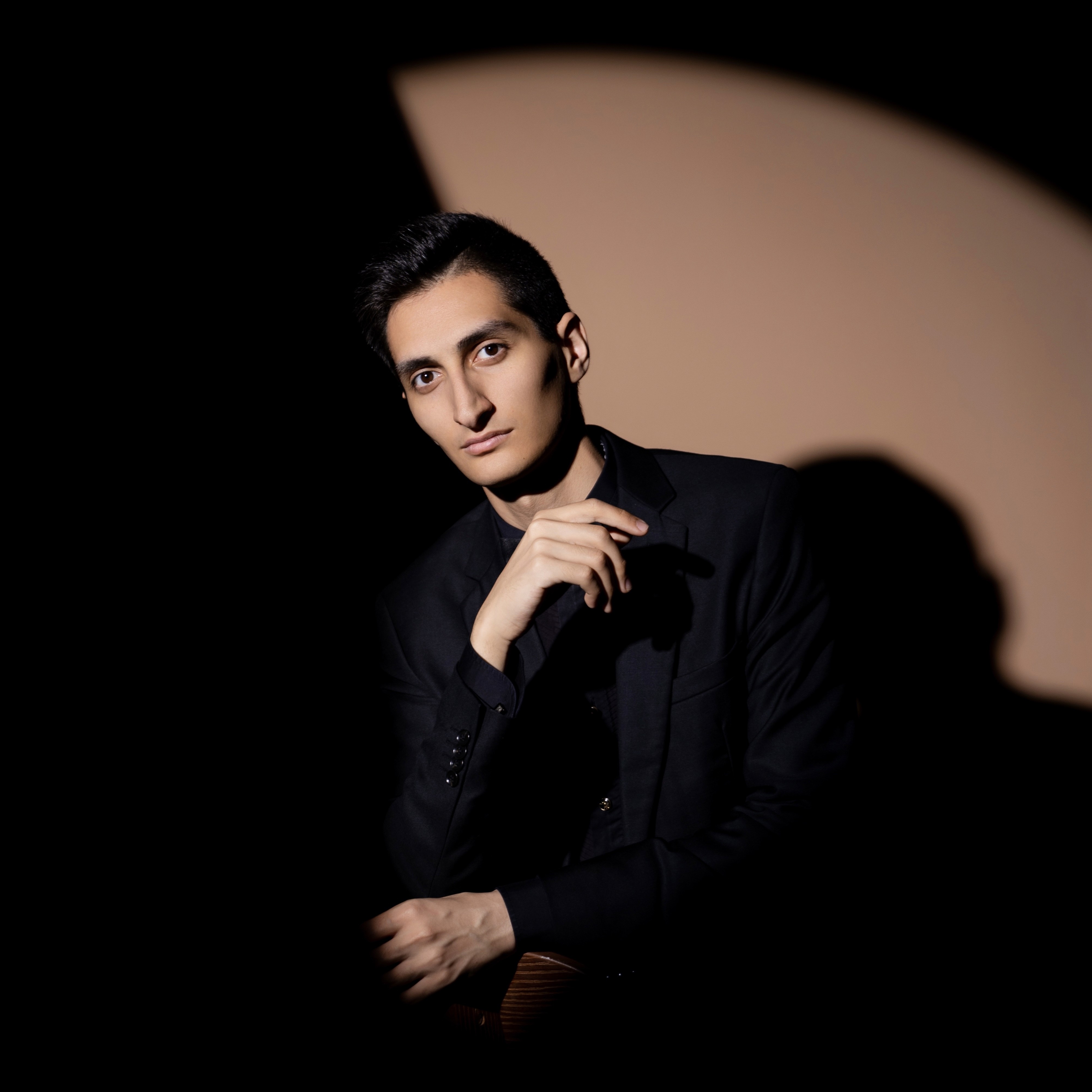     Erik Mirzoyan seated in a dark studio portrait