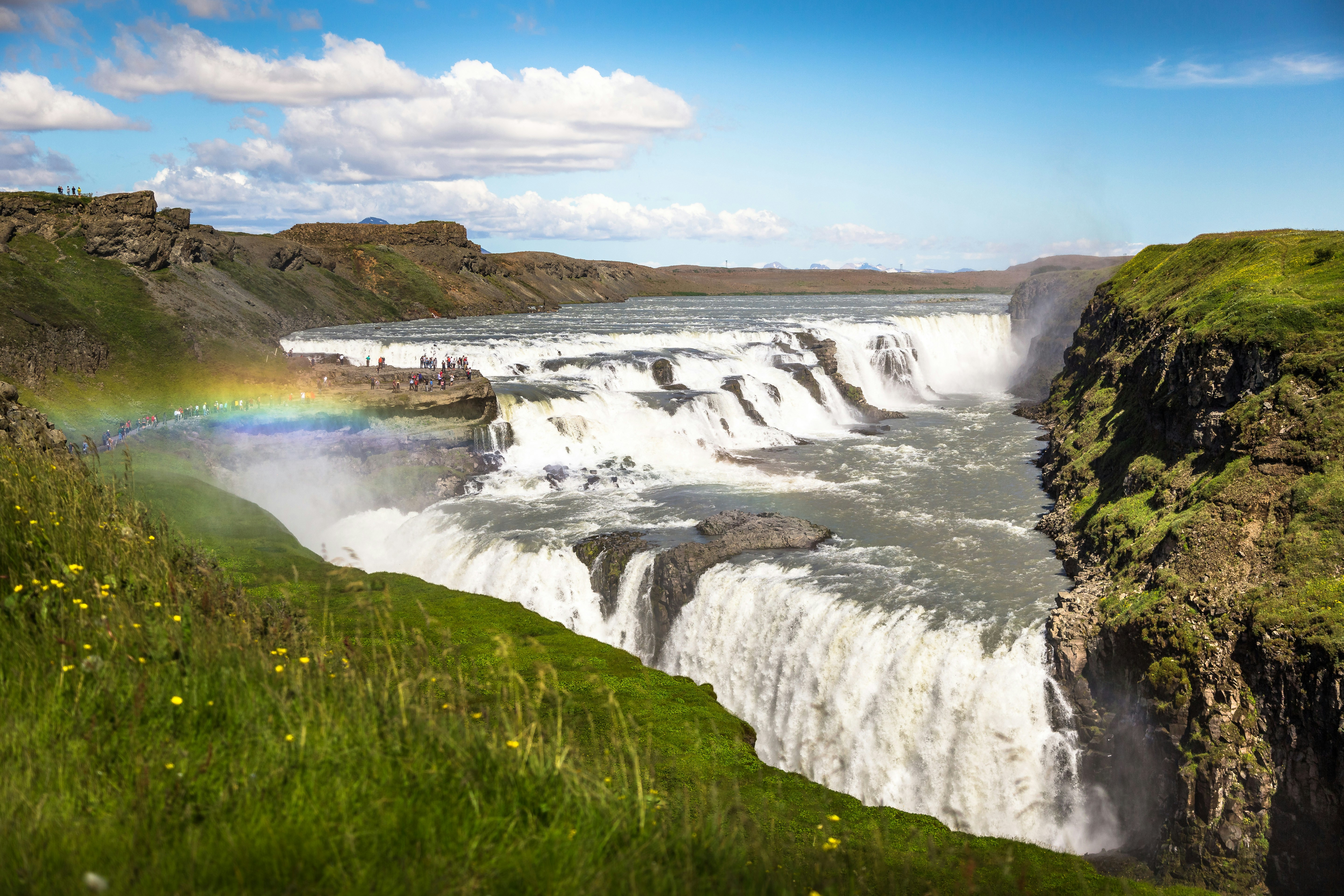 Gullfoss Waterfall with a rainbow forming in the mist on the Golden Circle.