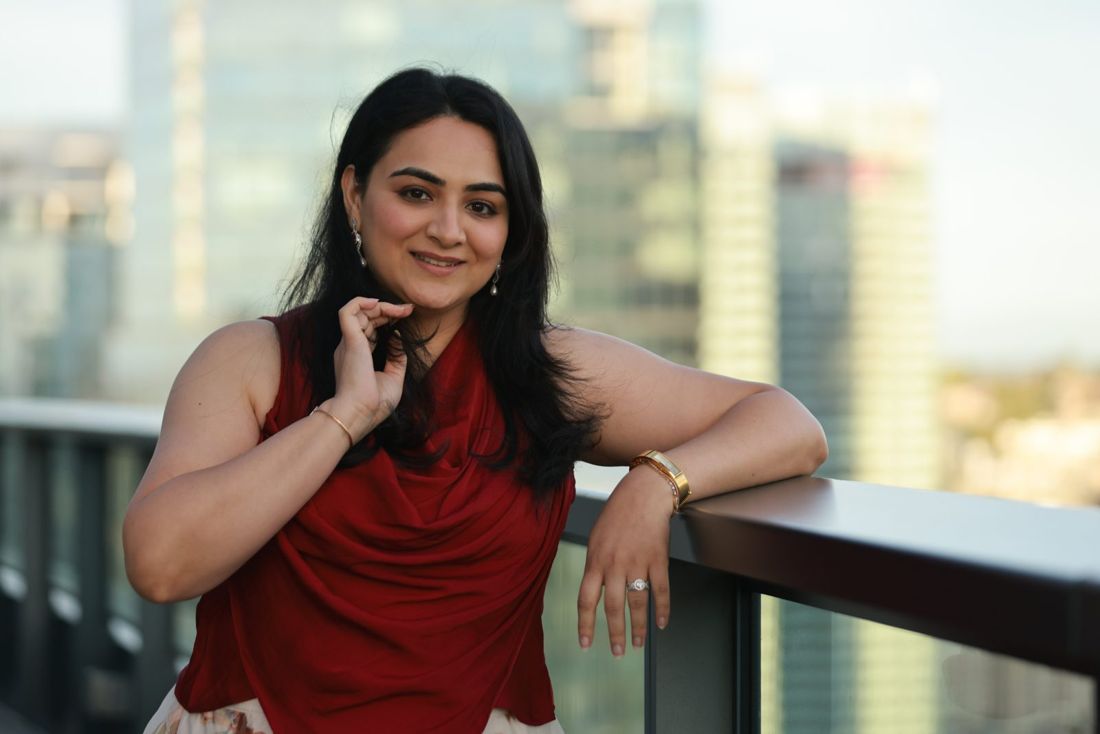 Karishma Wadhwani smiling on a city rooftop