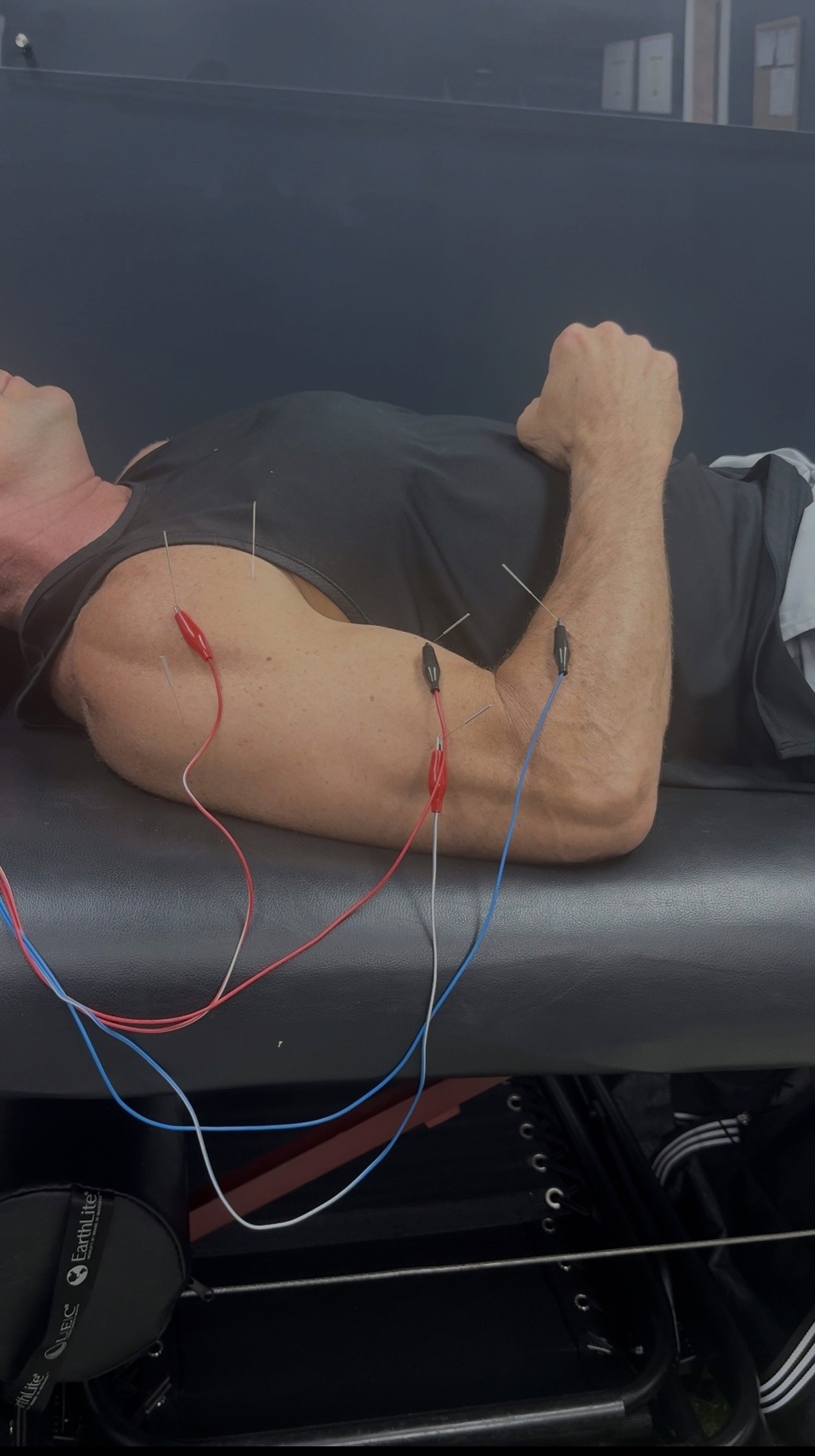 Fit female athlete resting post-workout, smiling with confidence—highlighting strength, recovery, and the results of consistent physical therapy and training.