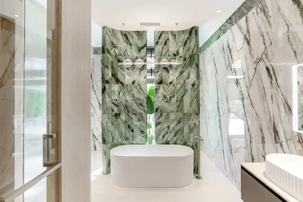 Bathroom with green fluted marbles and a bathtub.