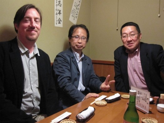 portrait of three men sitting around a table