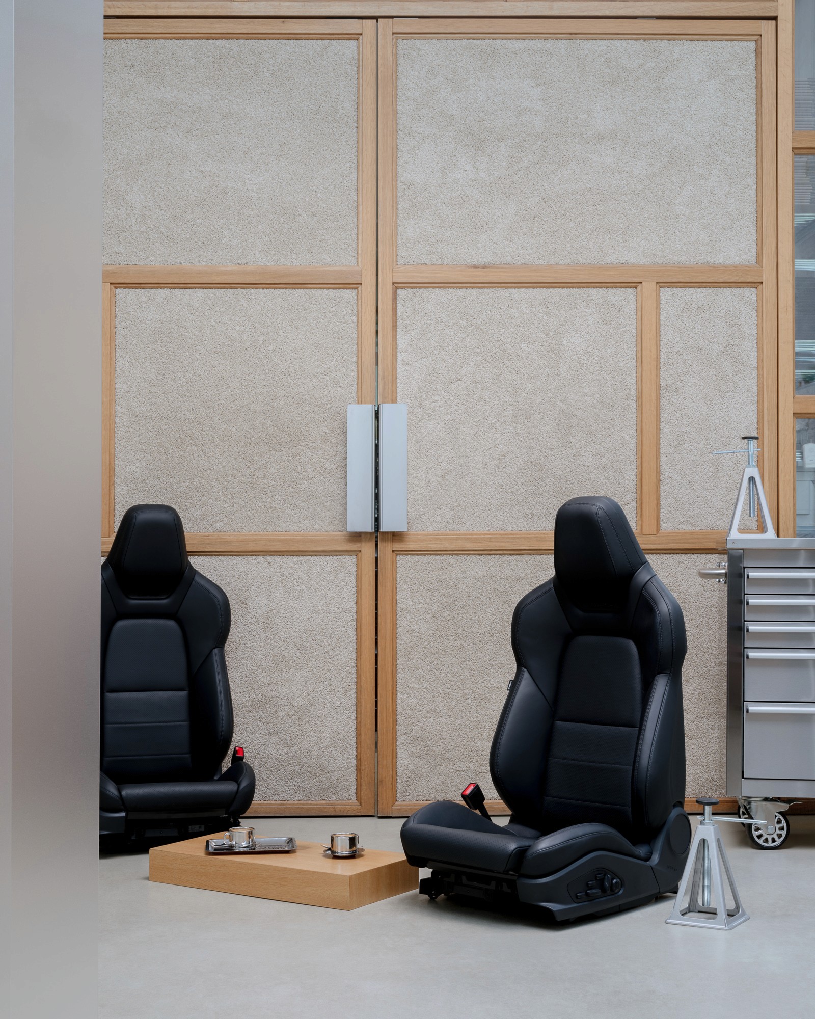 A view of a studio interior with modern decor, featuring large windows that offer a glimpse of lush greenery outside