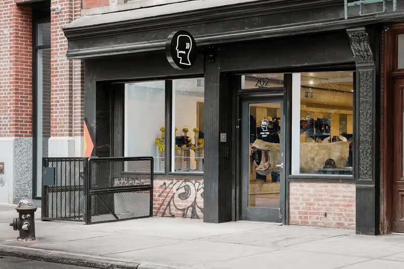 Hand holding a sleek black smartphone or mobile device against a light background