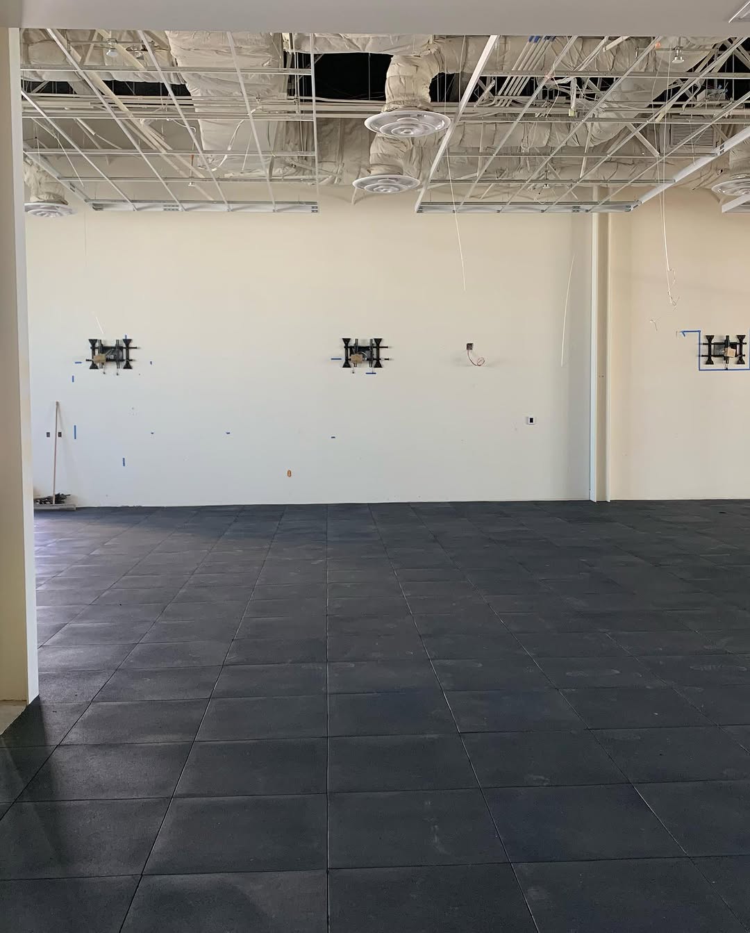 Rubber tile floor taking shape across an open room