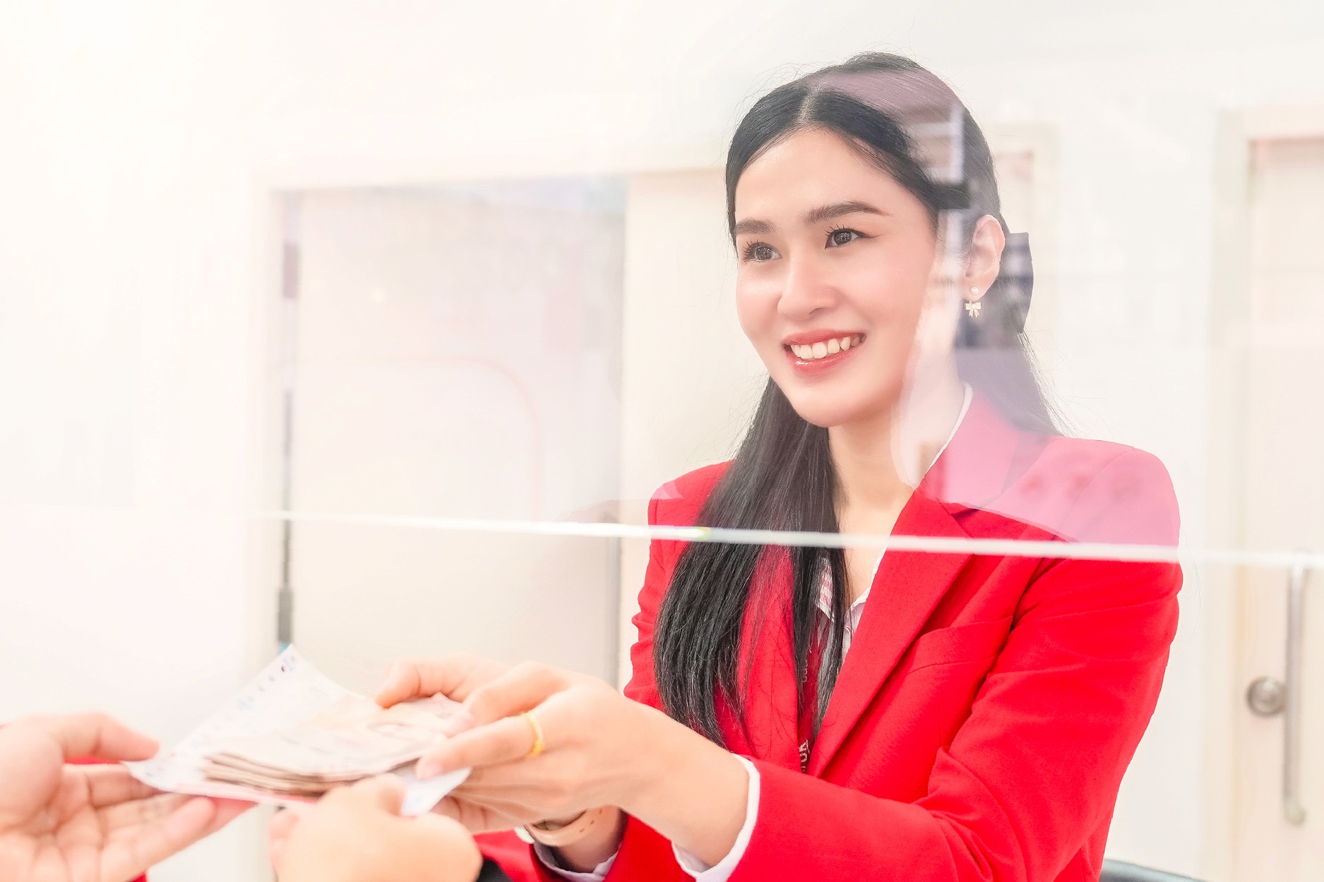 เจ้าหน้าที่มอบเงินสดให้ลูกค้าด้วยรอยยิ้ม