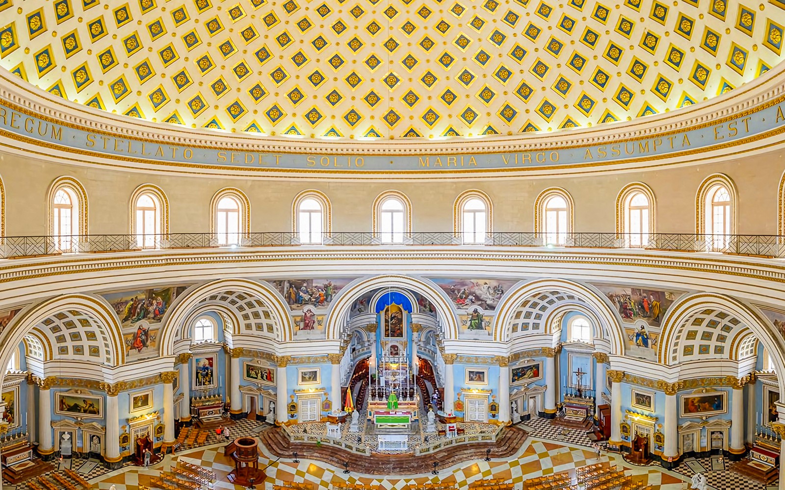 Interior of the Rotunda of Mosta, Malta, featuring ornate dome and religious artwork.