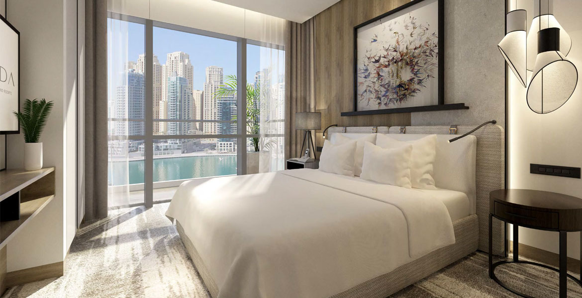  A stylish bedroom featuring large windows with a panoramic view of the Dubai city skyline.