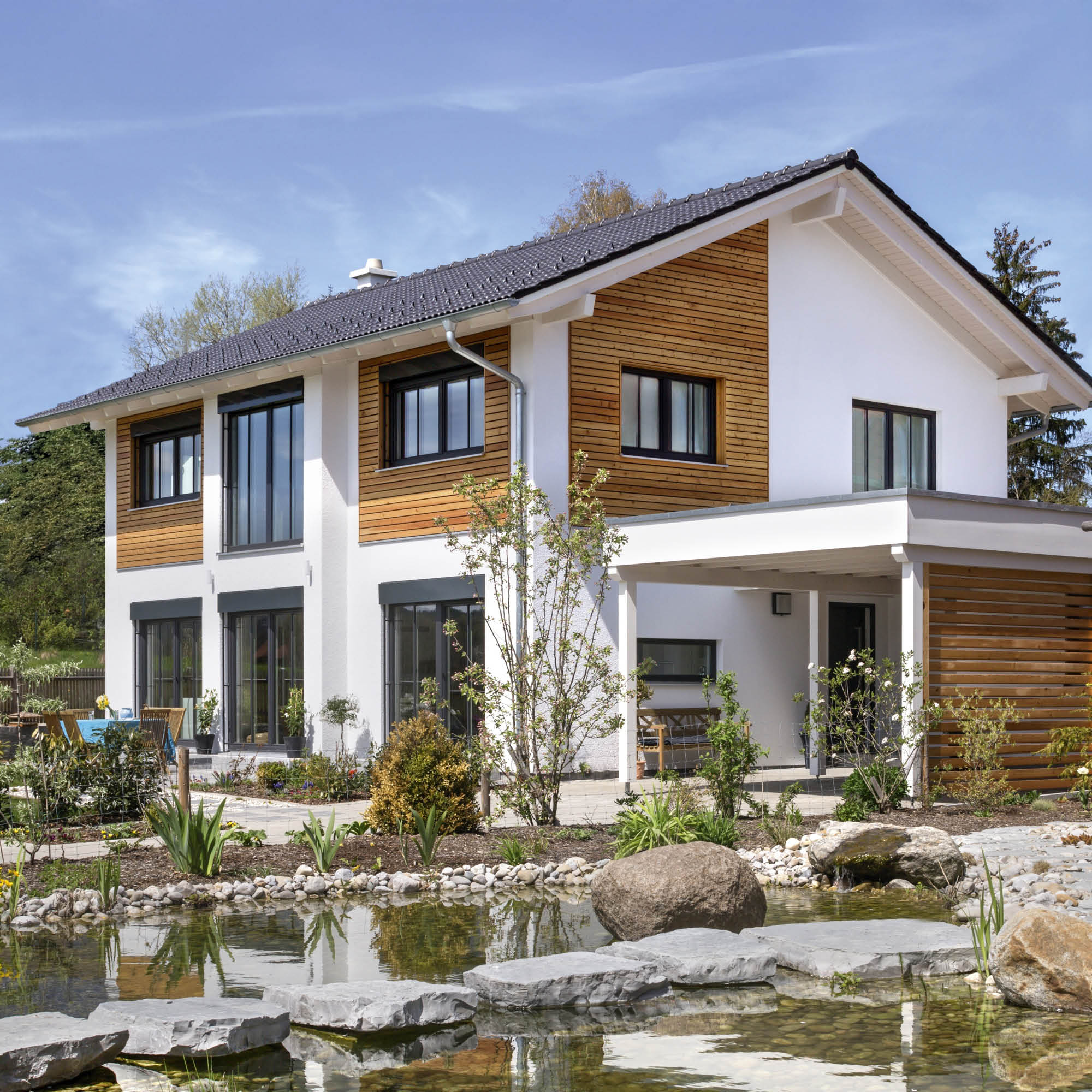 Zeitgenössisches Einfamilienhaus mit Holzfassade und Schwimmteich im Garten, klare Linien, grosse Fenster, moderner Garten.